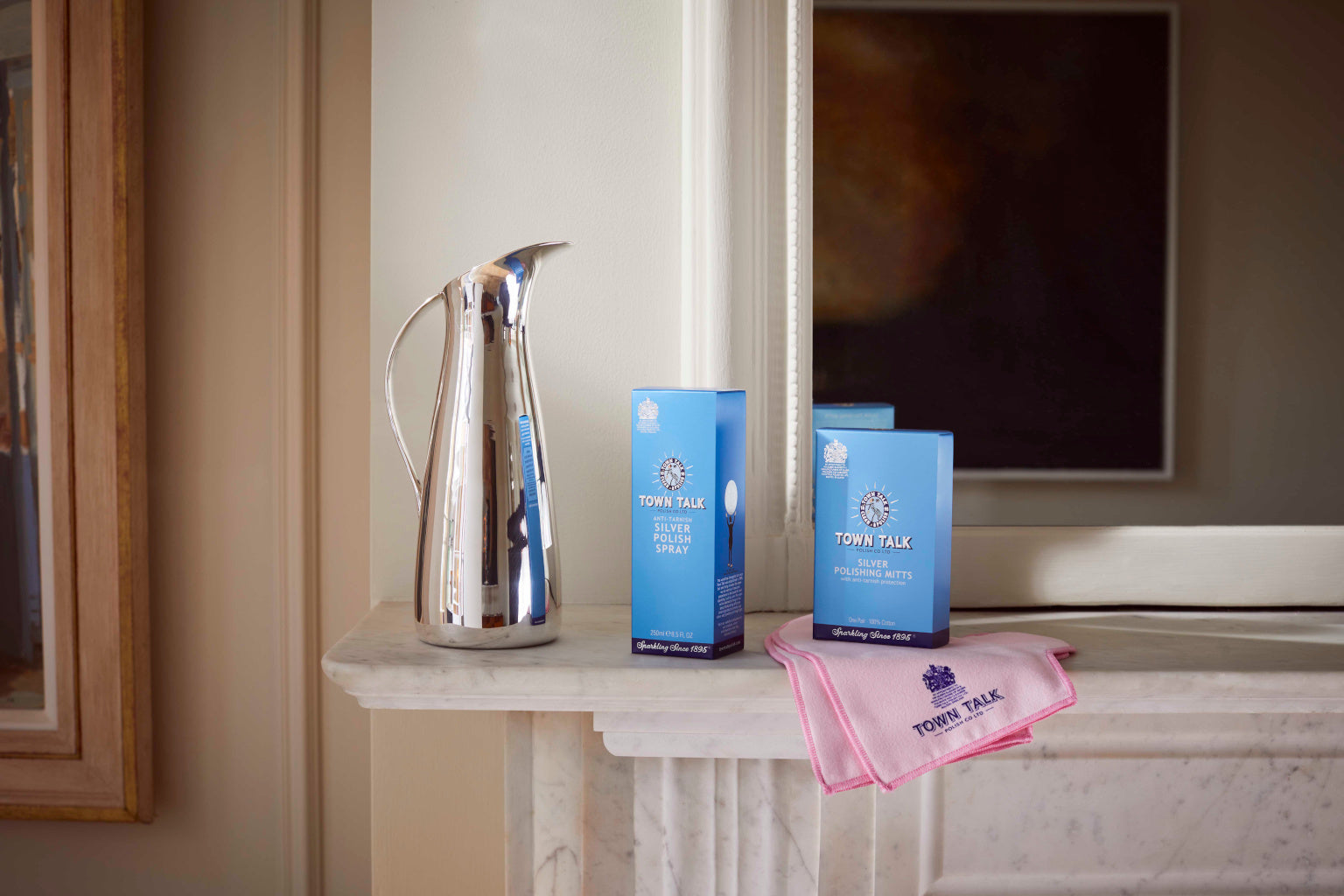 Town Talk Polish Silver Care Products Lifestyle Shot with Silver Polish Spray, Silver Polishing Mitts and Polishing Cloth on Marble Mantelpiece with Silver Pitcher